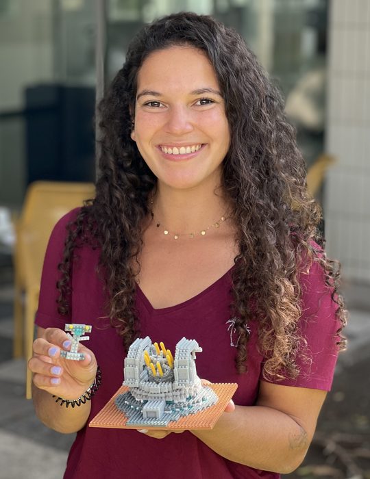 Emma Bordier holding a small model of a telescope